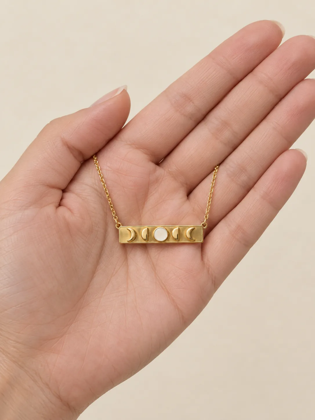 Moon Phase Bar Necklace — In the hand, for scale