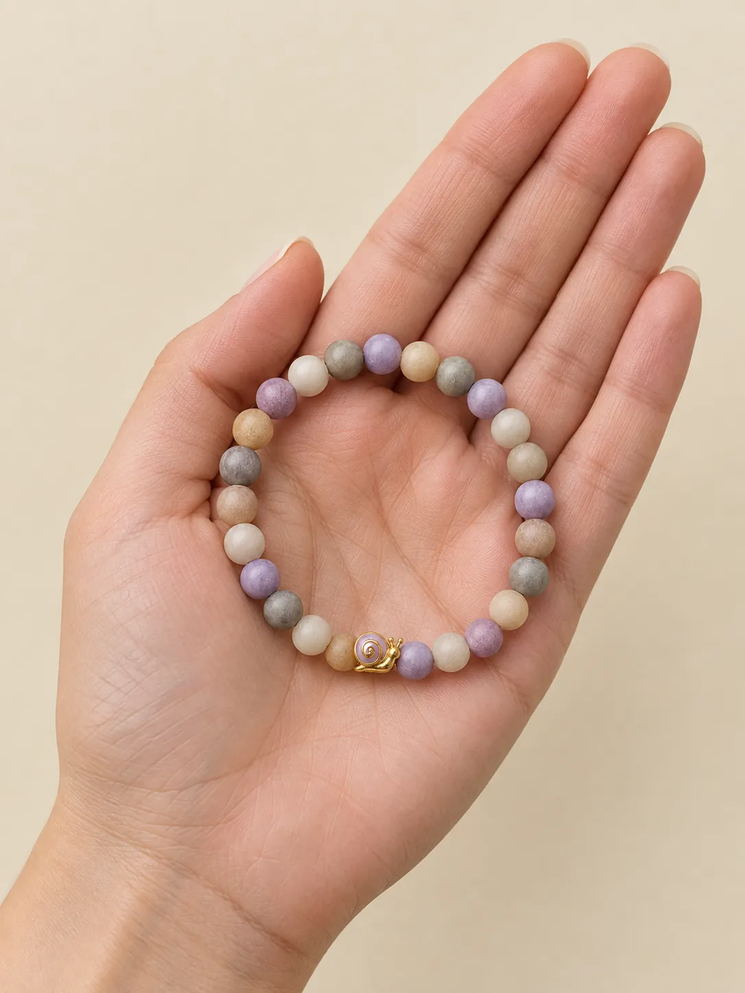 Pebble & Snail Beaded Bracelet — In the hand, for scale