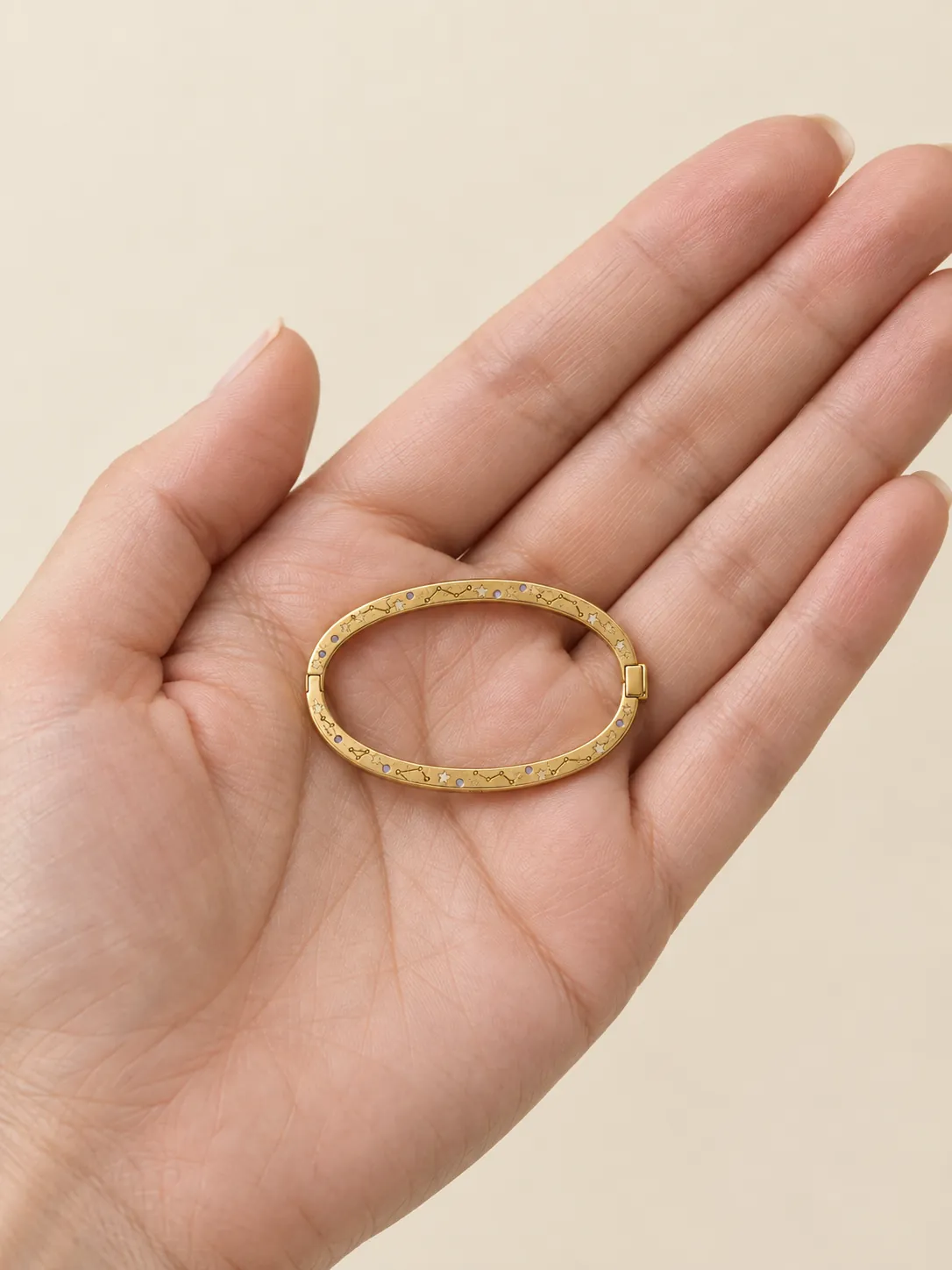 Star Map Hinged Bangle — In the hand, for scale